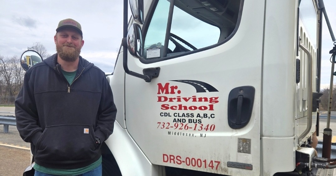 CDL student standing by training truck