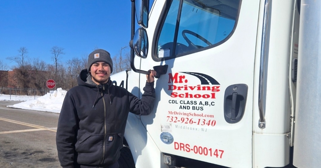 Happy student next to CDL training truck